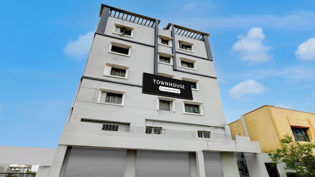 Un immeuble à plusieurs étages, sur lequel on peut voir une enseigne indiquant qu’il s’agit d’une maison de ville gérée par une entreprise.