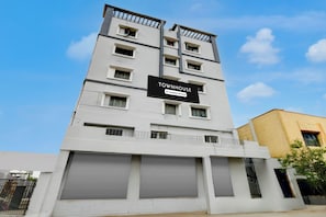 Un edificio de varios pisos con un letrero que indica que es una casa adosada con servicios de empresa.