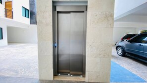 Ein moderner Aufzug mit Metalloptik, eingebaut in ein Gebäude mit klarem, minimalistischem Design.
