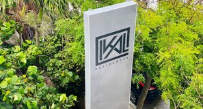 A sign with the logo and name of a hotel, surrounded by lush greenery. - Beachfront Views next to the pier (Puerto Morelos)