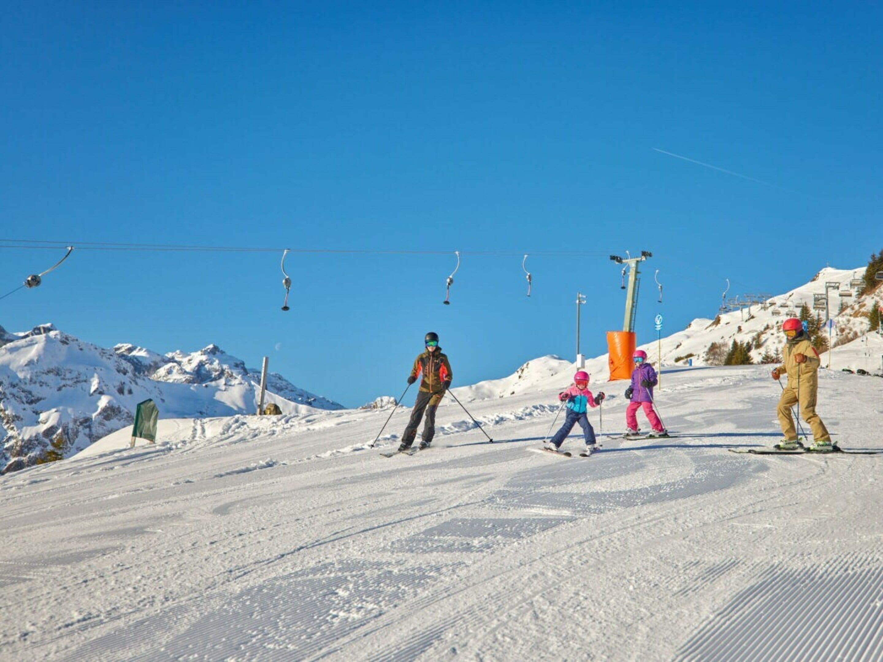 Une piste de ski avec des skieurs et un télésiège.