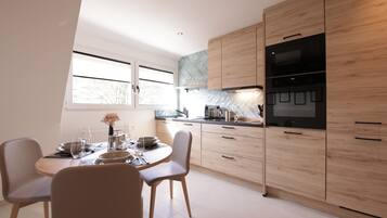 A modern kitchen with wooden cabinets, a dining table set for four, and a large window.