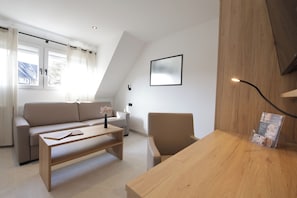 Ein stilvolles Wohnzimmer mit einer Couch, einem Couchtisch, einem Sessel und einem Holzbüro.