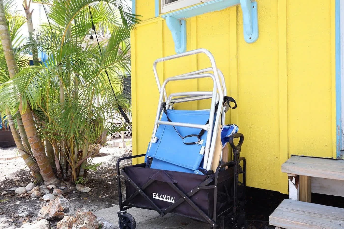 Una silla de ruedas frente a un edificio amarillo con marco azul.