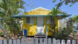 Ein gelbes Haus mit Veranda, Briefkasten und der Hausnummer 5306 an der Tür.