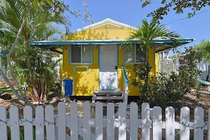A yellow house with a porch, a mailbox, and a number 5306 on the door.