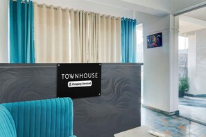A reception area with a sign reading 'TOWNHOUSE Company-Serviced.' - Townhouse Oak Sankaramatam Road (Visakhapatnam)