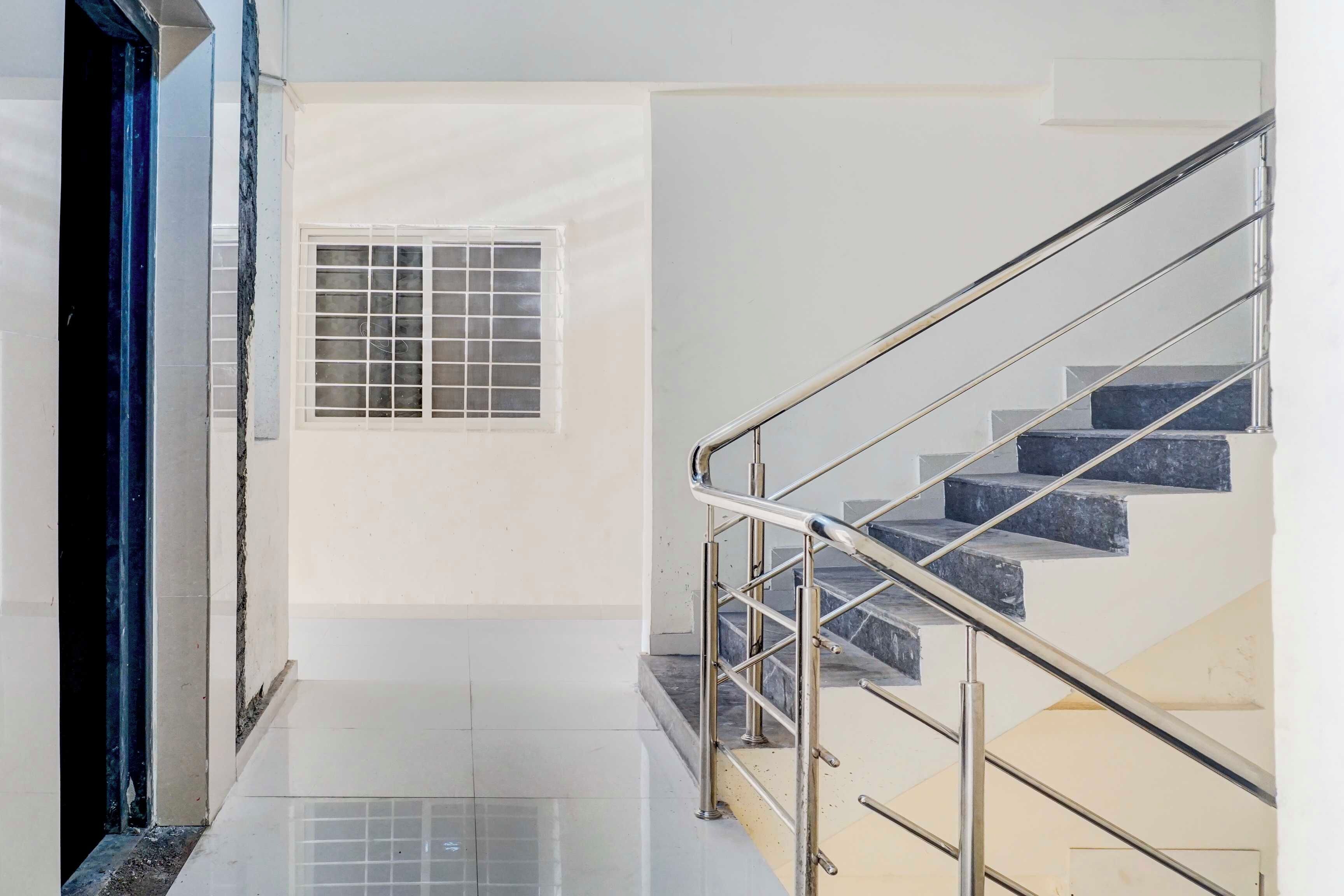 A modern interior with a staircase, a small window, and a door.