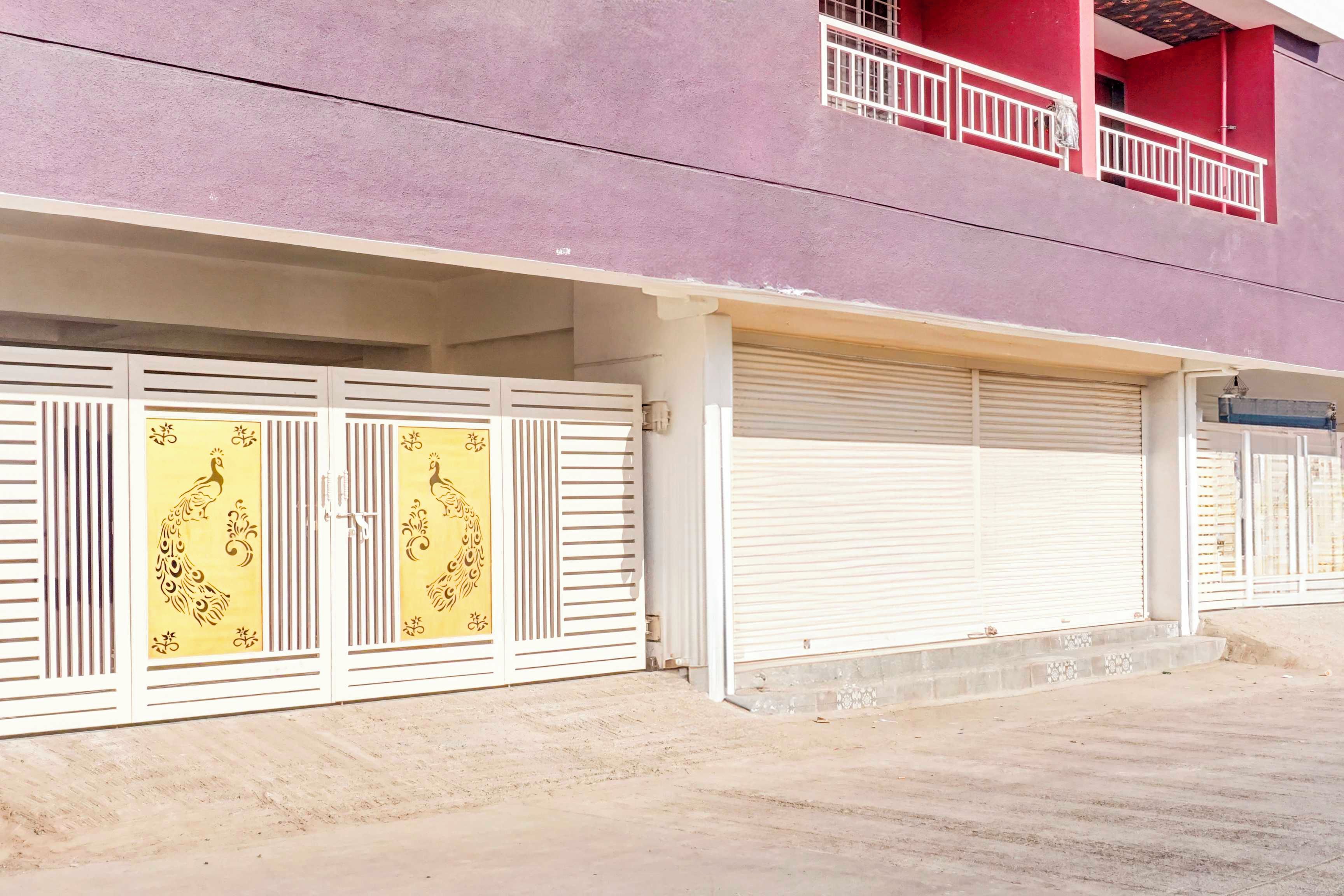A building with a purple facade, a closed white shuttered door, and a balcony with a red railing.