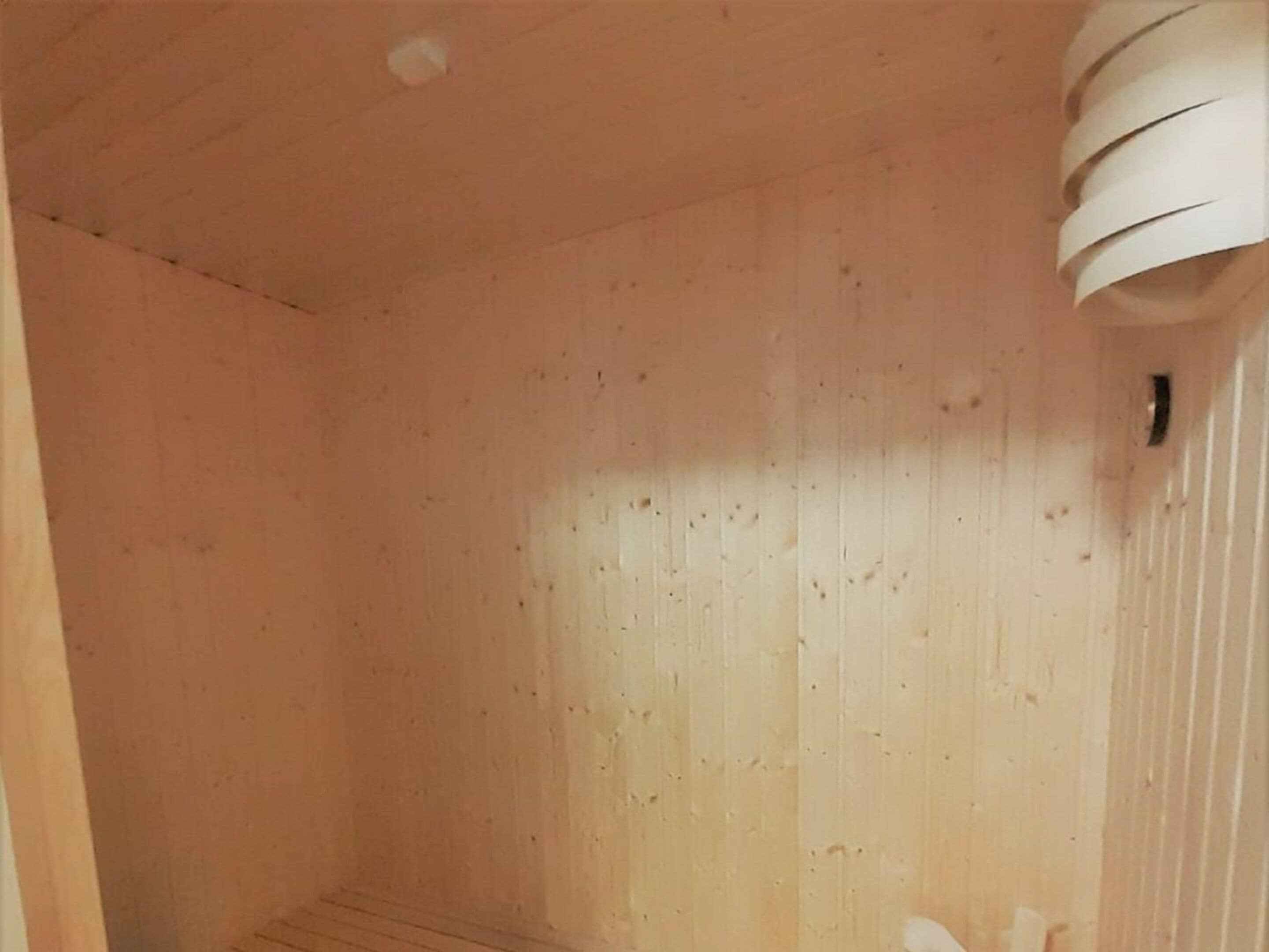 Una stanza con pareti in legno e un soffitto con un lampadario circolare.
