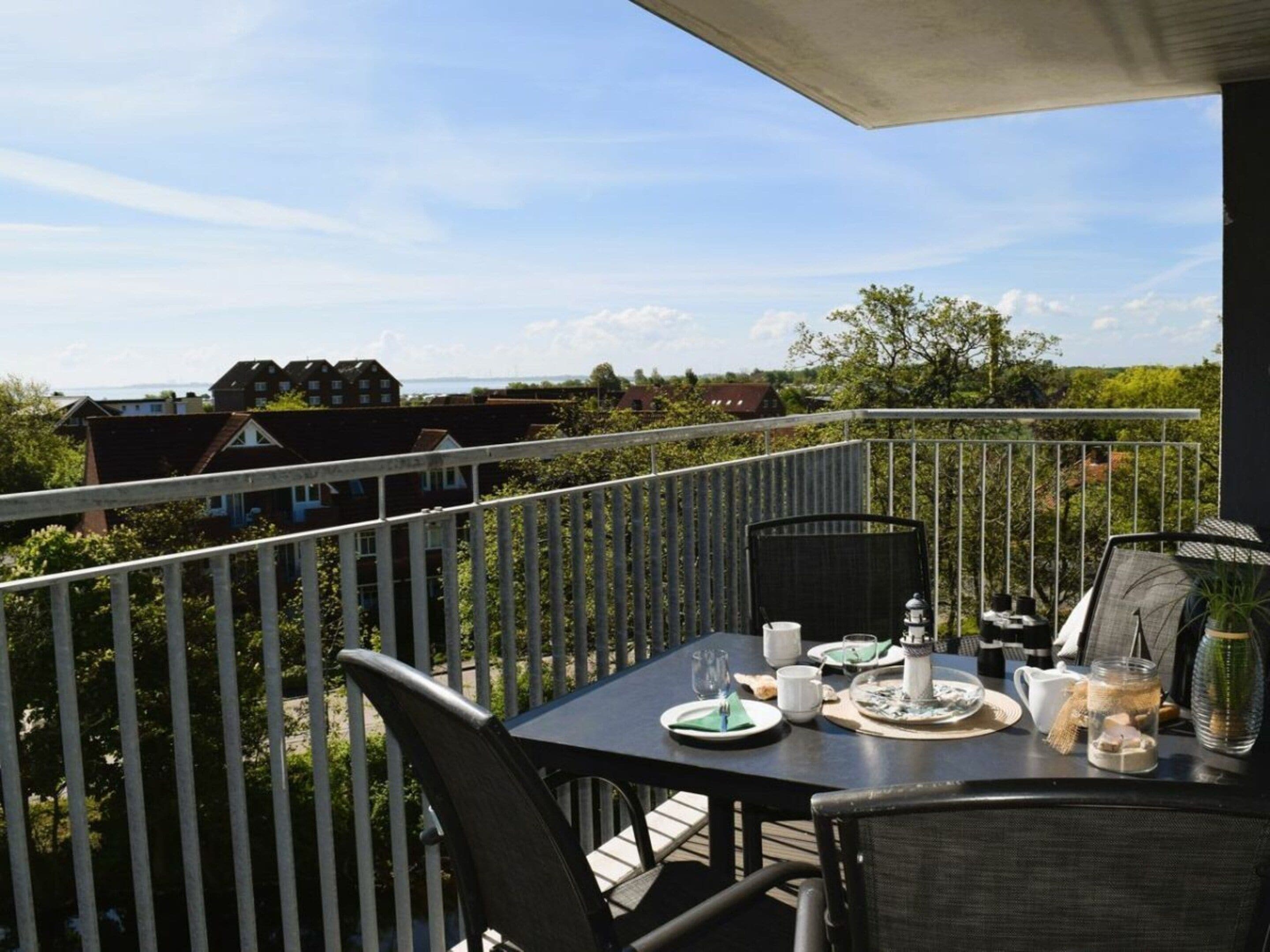 Ein Balkon mit Esstisch, der auf einen Wohnbereich blickt.