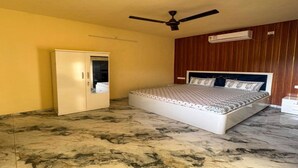 Un dormitorio con cama, armario, ventilador de techo y equipo de aire acondicionado.