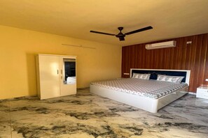 Un dormitorio con cama, armario, ventilador de techo y equipo de aire acondicionado.