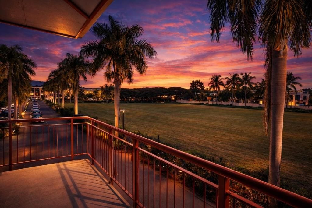 Un balcon avec vue sur un terrain de golf au coucher du soleil.