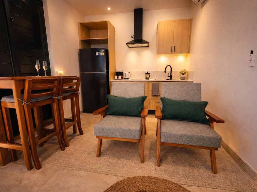 Een kleine keuken met een eethoek, inclusief een tafel en stoelen, en een ingebouwde kookplaat.