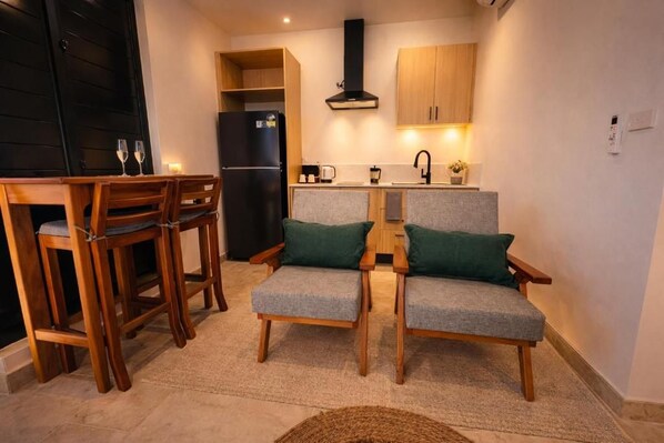 A compact kitchen with a dining area, including a table and chairs, and a built-in stove.