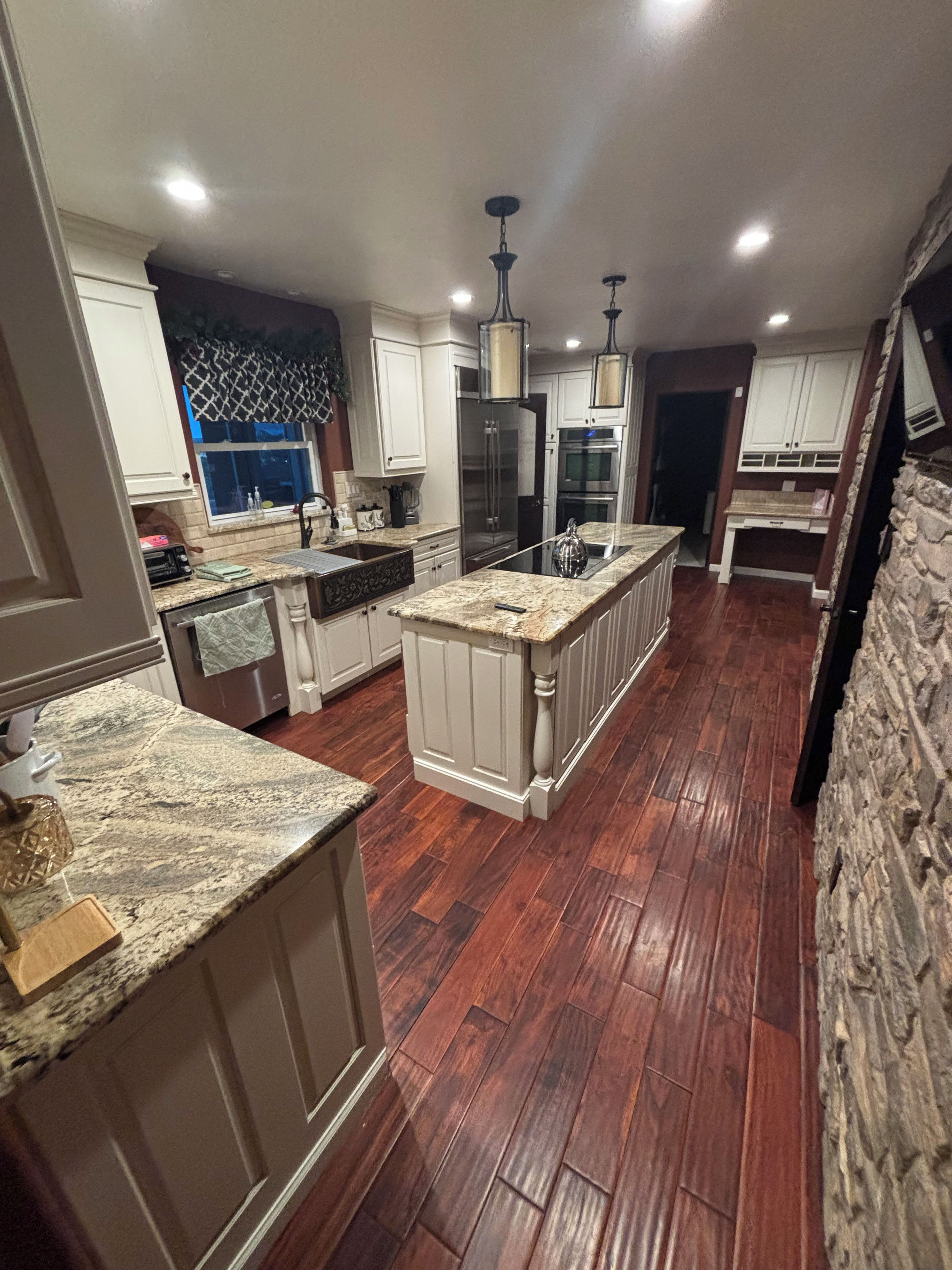 A modern kitchen with granite countertops, stainless steel appliances, and a central island.