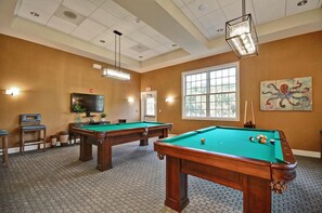 A pool room with two pool tables, a television, and a large window. - Beautiful OVBC townhouse steps from the Amenities! Wifi, Pool, Fitness Center, Sauna, Weekend Shuttle! (Ocean View)