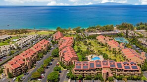 A resort with multiple buildings, a swimming pool, and a view of the ocean. - Top-Floor With Views I Kamaole Sands 6410 (Kihei)