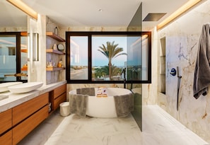 Ein modernes Badezimmer mit einer großen Badewanne, einem doppelten Waschbecken und einem großen Spiegel.