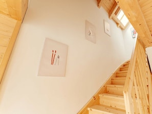 A wooden staircase leading to a higher floor with a white wall featuring three framed pictures. - Cabin in Niederwolz With Sauna (Oberwölz)