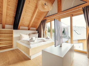 A modern bedroom with a loft bed, a large window, and a view of the outside. - Cabin in Niederwolz With Sauna (Oberwölz)
