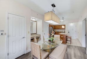 A modern kitchen with wooden cabinets, a refrigerator, and a microwave. - Magical 2BR Disney Condo - Free Resort Access (Orlando)