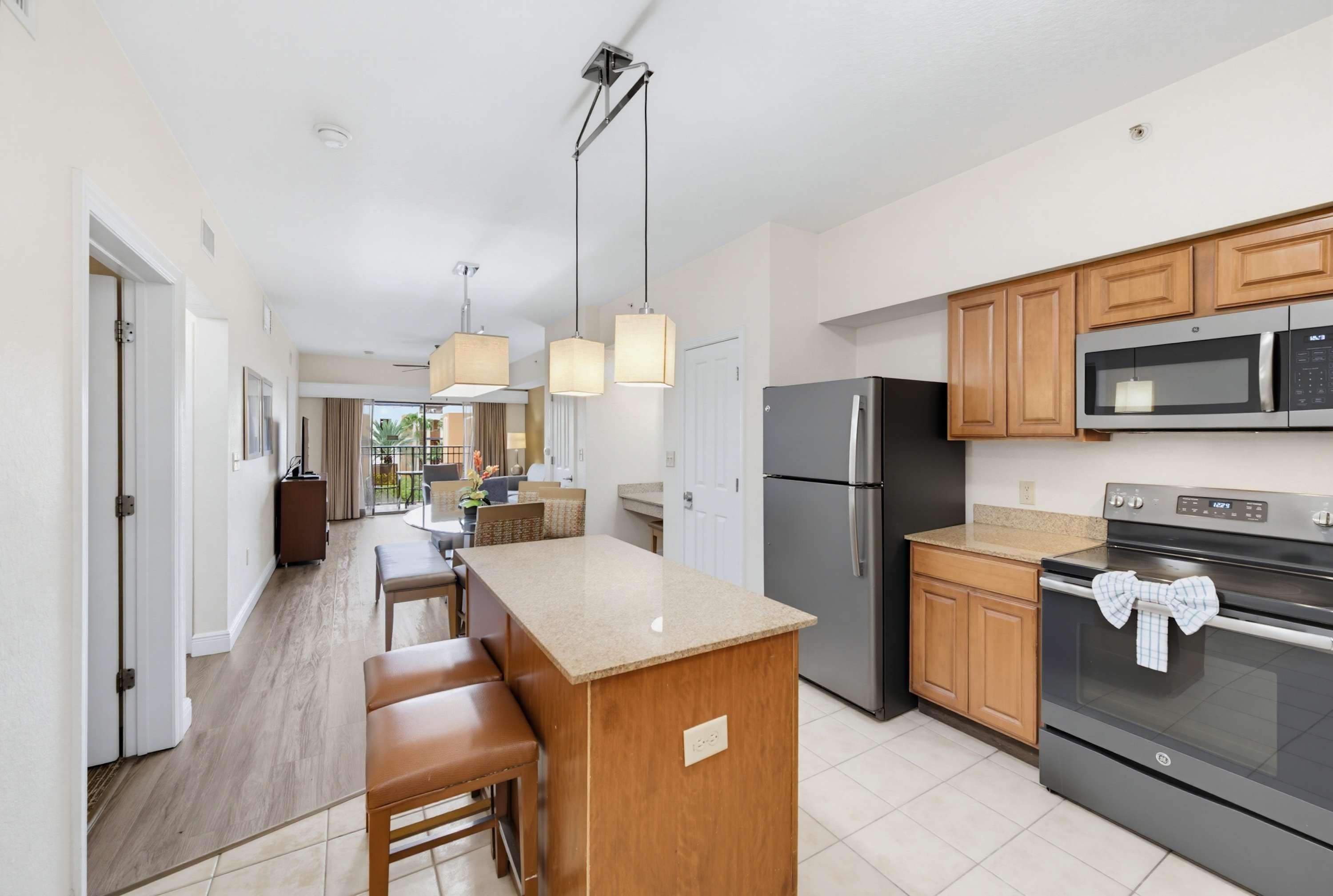 A modern kitchen with a central island, stainless steel appliances, and wooden cabinetry.