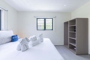 A hotel room with a bed, a window with blinds, a wardrobe, and towels on the bed. - Altura Luxury 3BR Penthouse by Mambo Beach (Willemstad)
