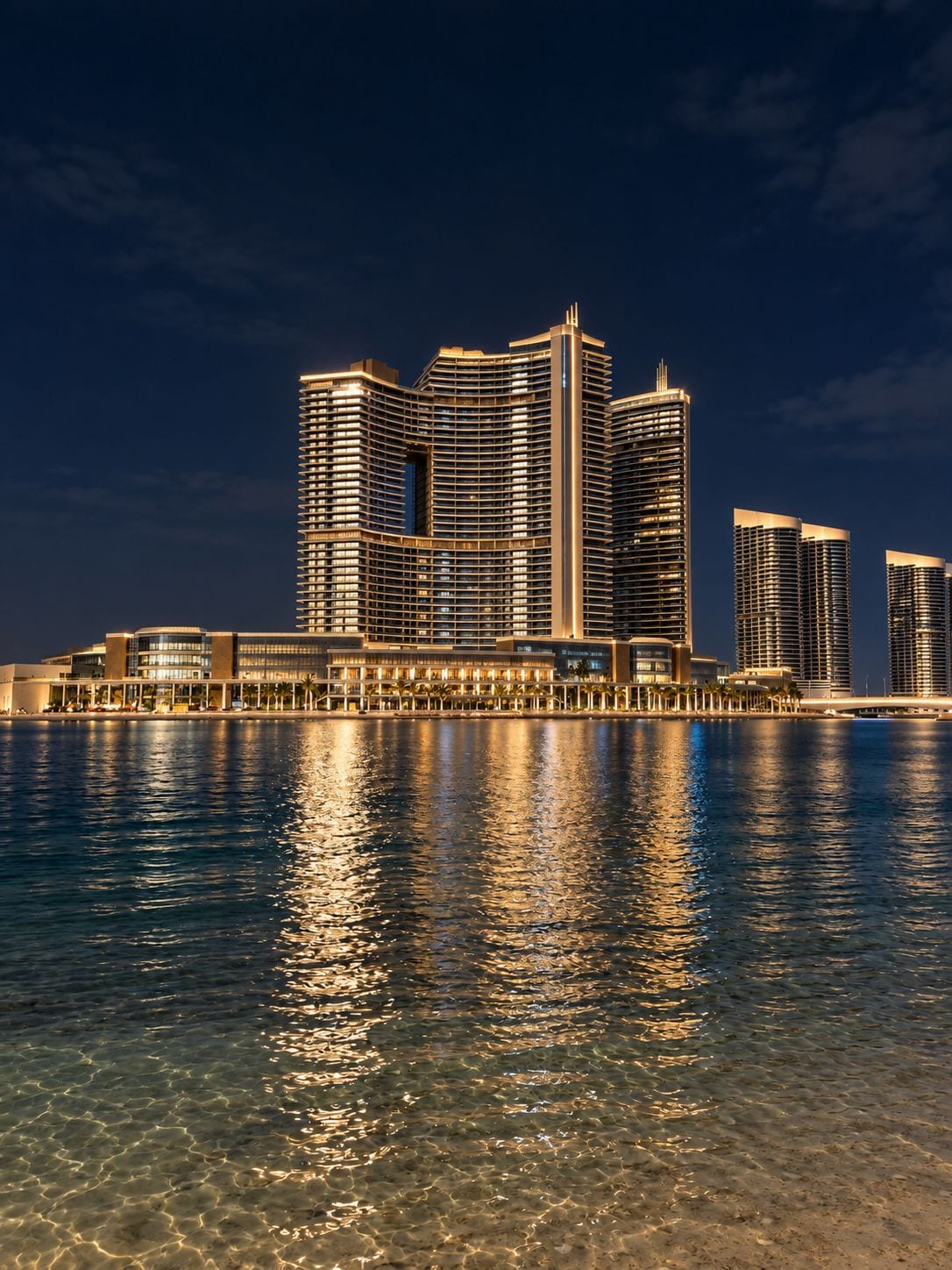 Ein Hotel am Wasser mit mehreren Hochhäusern, die sich im Wasser spiegeln.