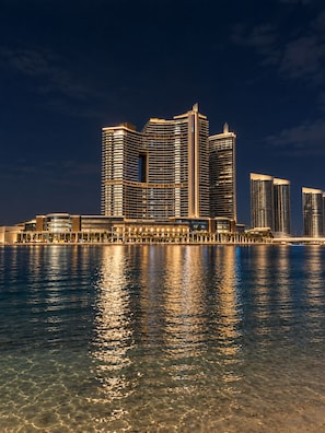 Un hotel frente al agua con varios edificios altos que se reflejan en el agua.