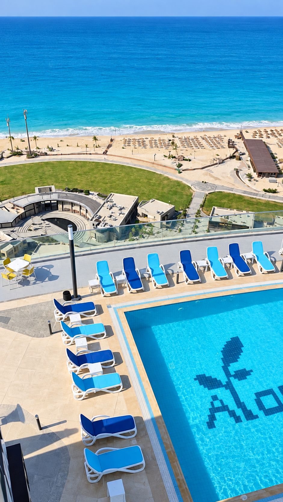 Ein Poolbereich mit Liegestühlen und freiem Blick auf den Ozean.