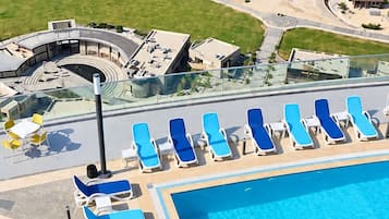 Ein Poolbereich mit Liegestühlen und freiem Blick auf den Ozean.