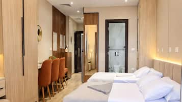 Ein modernes Hotelzimmer mit einem großen Bett, einem Schreibtisch und einem Essbereich.