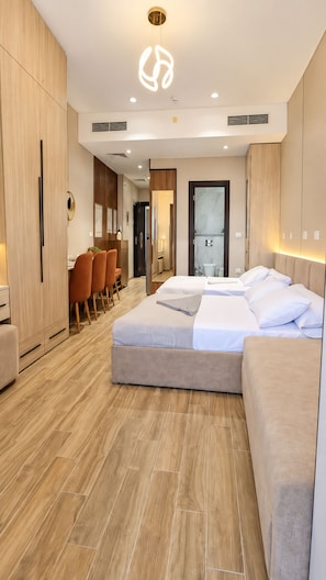 Una habitación de hotel moderna con una cama grande, un escritorio y un área de comedor.
