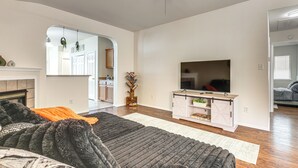 Sala de estar com lareira, televisão e um tapete grande.
