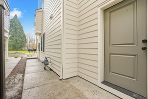 A house exterior with a beige door, a small outdoor utility area, and a clear sky. - PNW Home Base! Gresham Studio w/ Patio (Gresham)