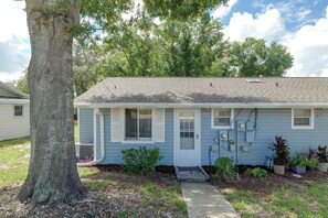 A single-story house with a front porch, a small front yard, and a tree to the left. - Rum Away With Me: Resort Pool, Dock + Beach (Clermont)