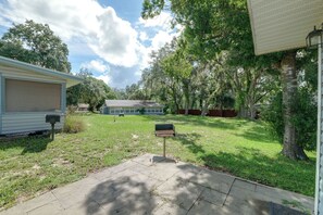 A residential backyard with a patio, a barbecue grill, and a mobile home. - Rum Away With Me: Resort Pool, Dock + Beach (Clermont)