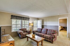 A living room with a plaid sofa set, a wooden coffee table, and a television on a wooden stand. - Quiet Extended Stay Near Rivanna River (Palmyra)