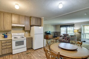 A compact kitchen with wooden cabinets, a white stove, and a refrigerator. - Quiet Extended Stay Near Rivanna River (Palmyra)