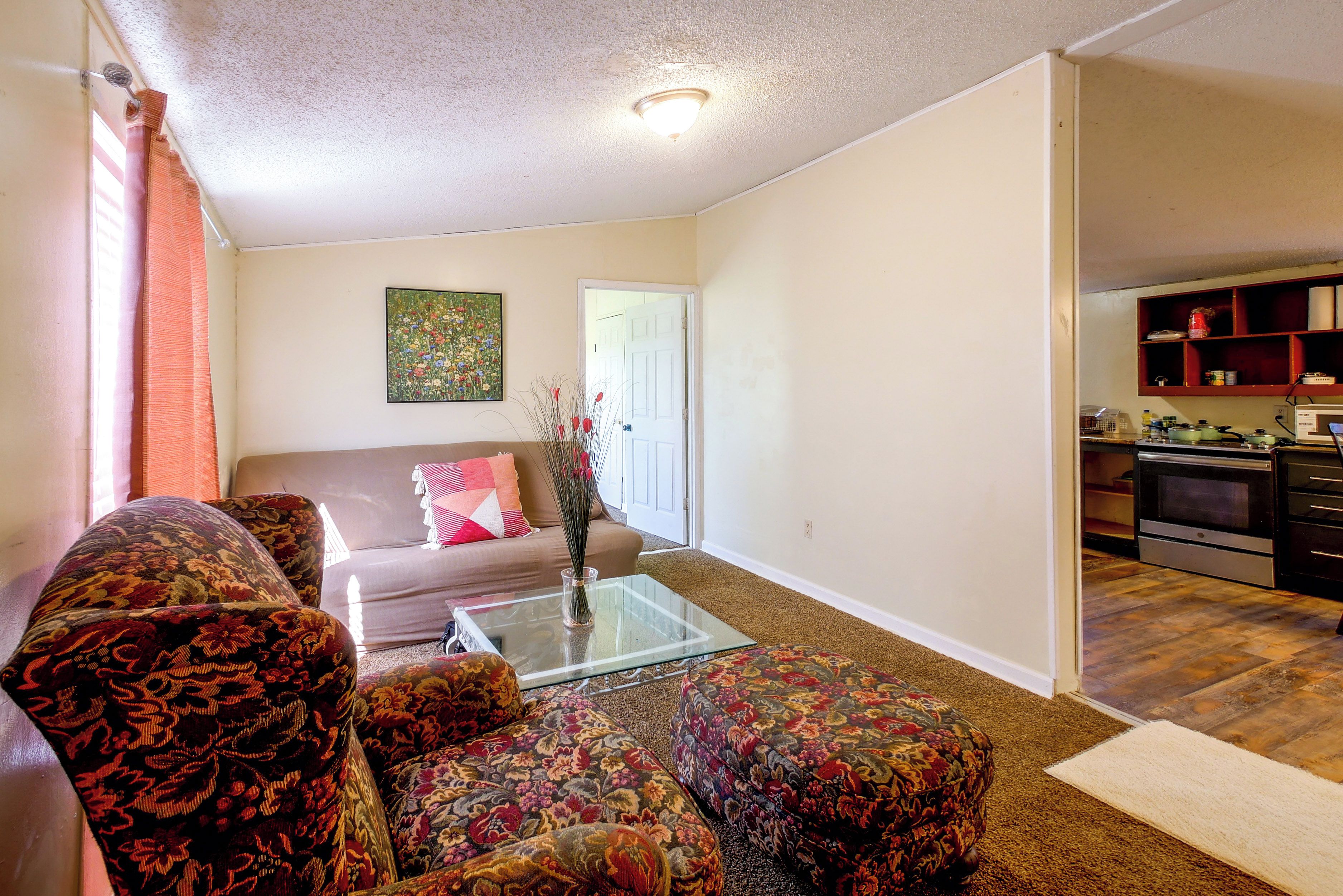A living room with a sofa, a coffee table, and a painting on the wall.