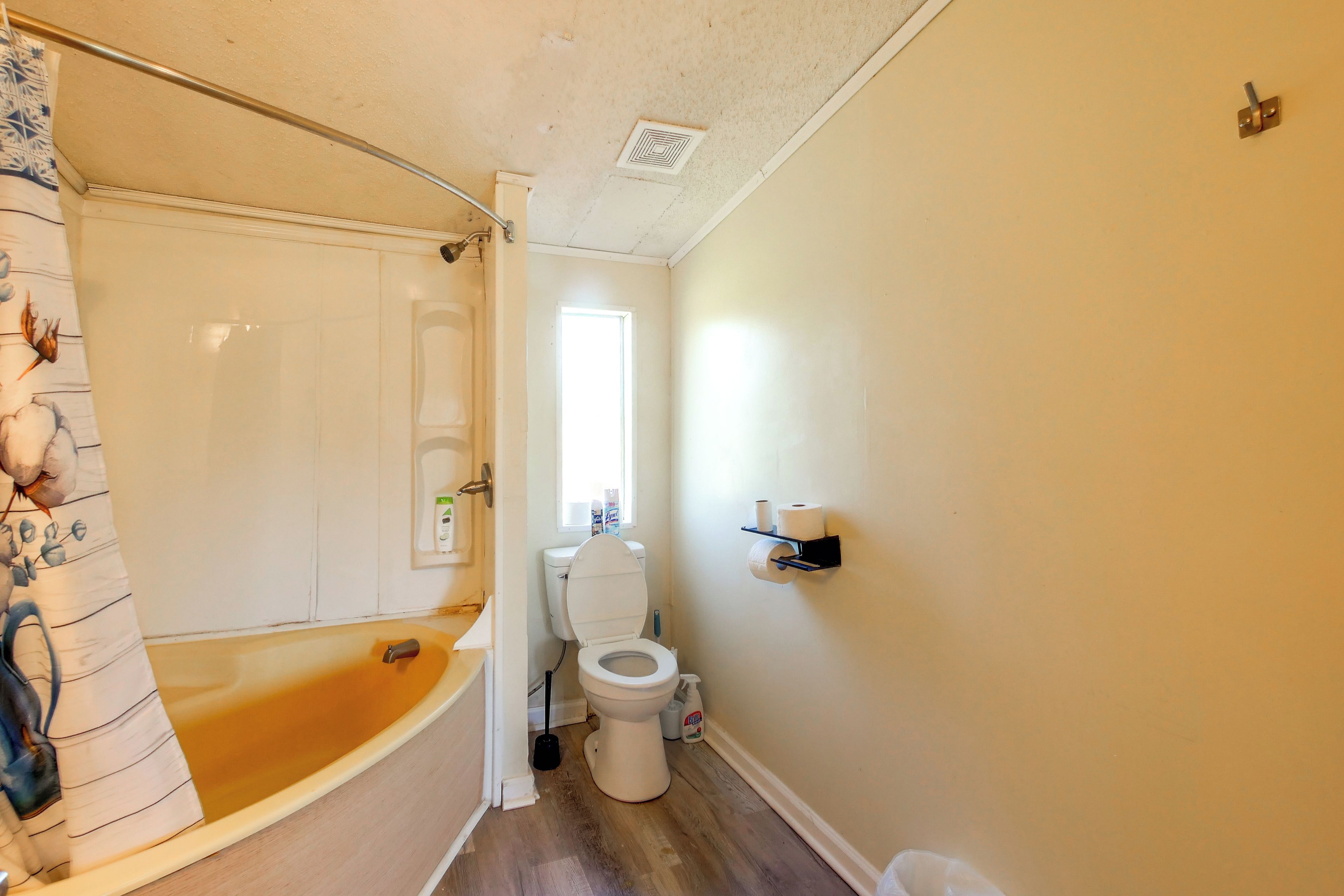 Un bagno con vasca, servizi igienici e tenda da doccia.