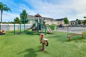 A playground with a slide, climbing structures, and a seesaw. - Pool Access! Kissimmee Gem, Enclosed Patio (Kissimmee)