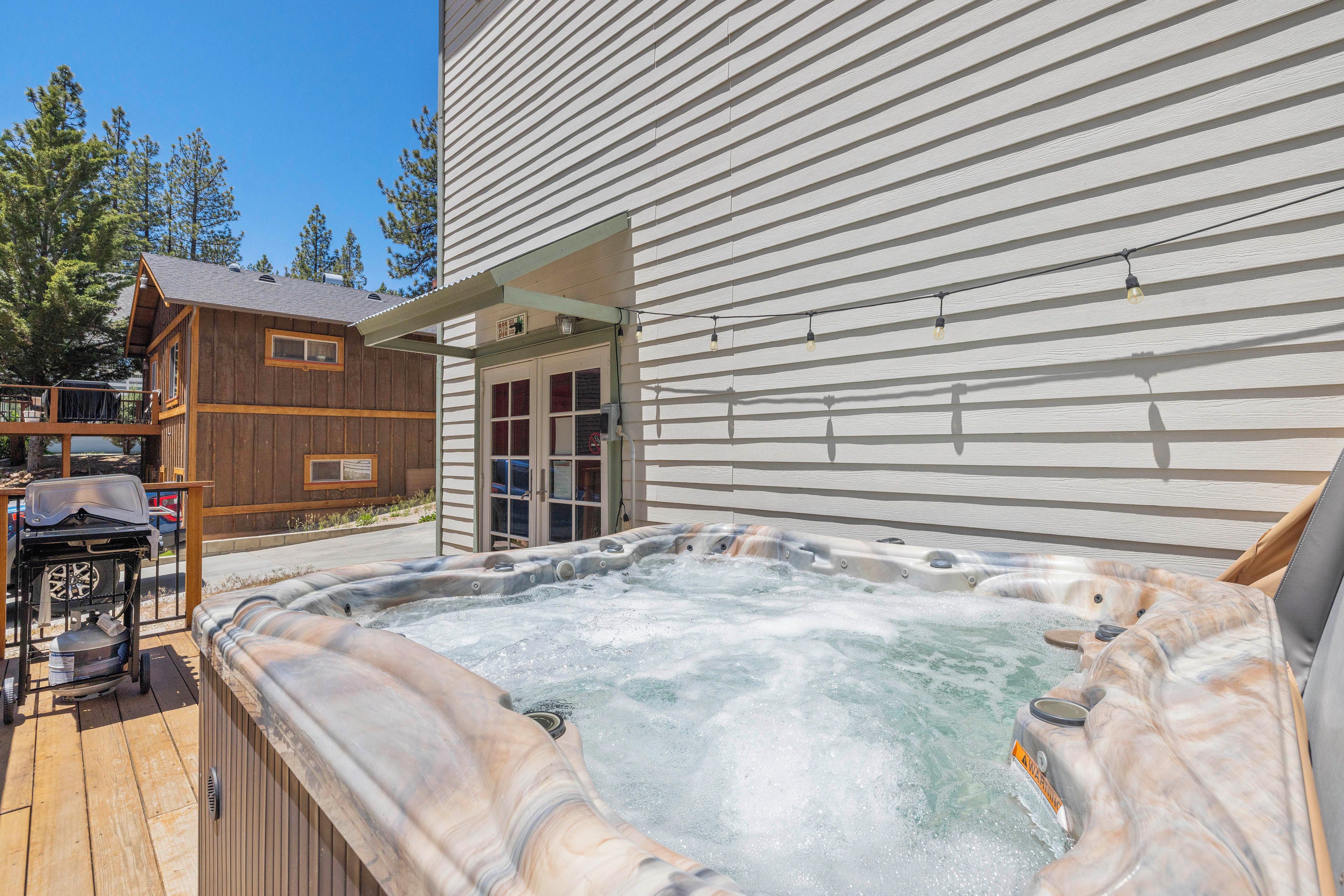 Une cabane en bois avec un bain à remous et un espace salon extérieur.