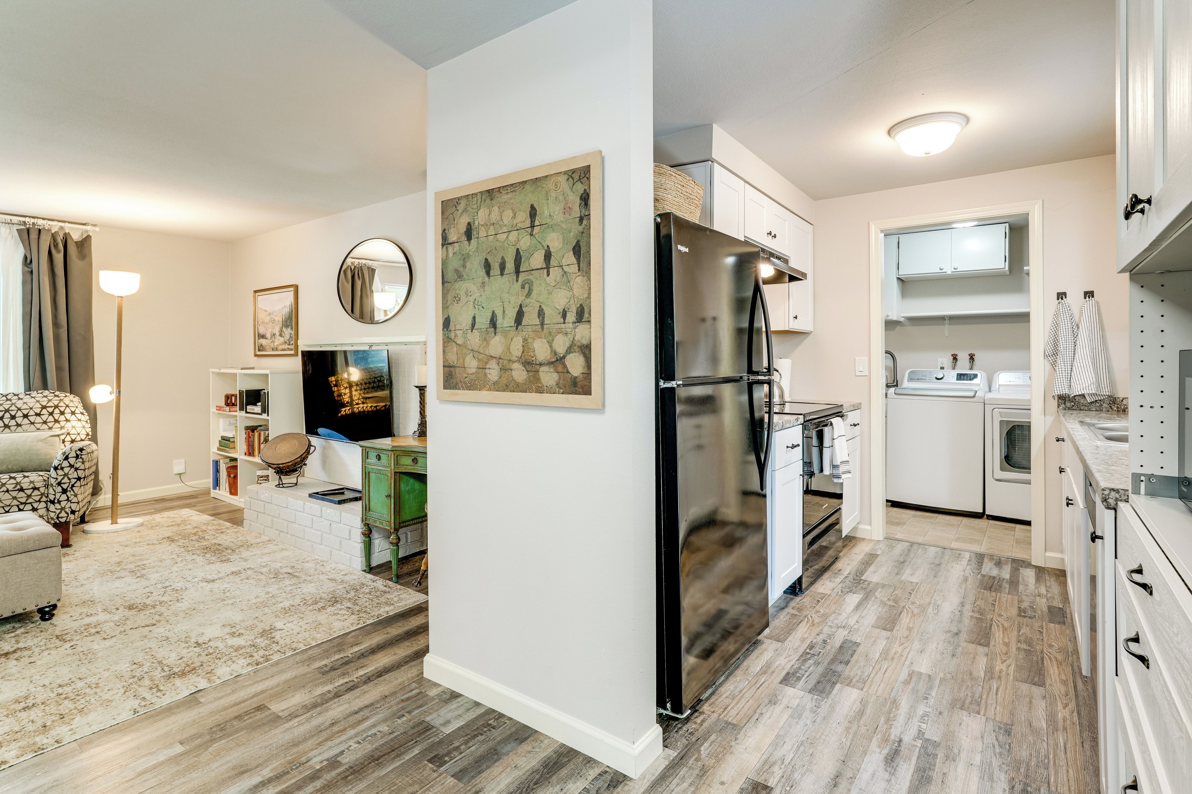A modern kitchen with a refrigerator, oven, and washing machine.