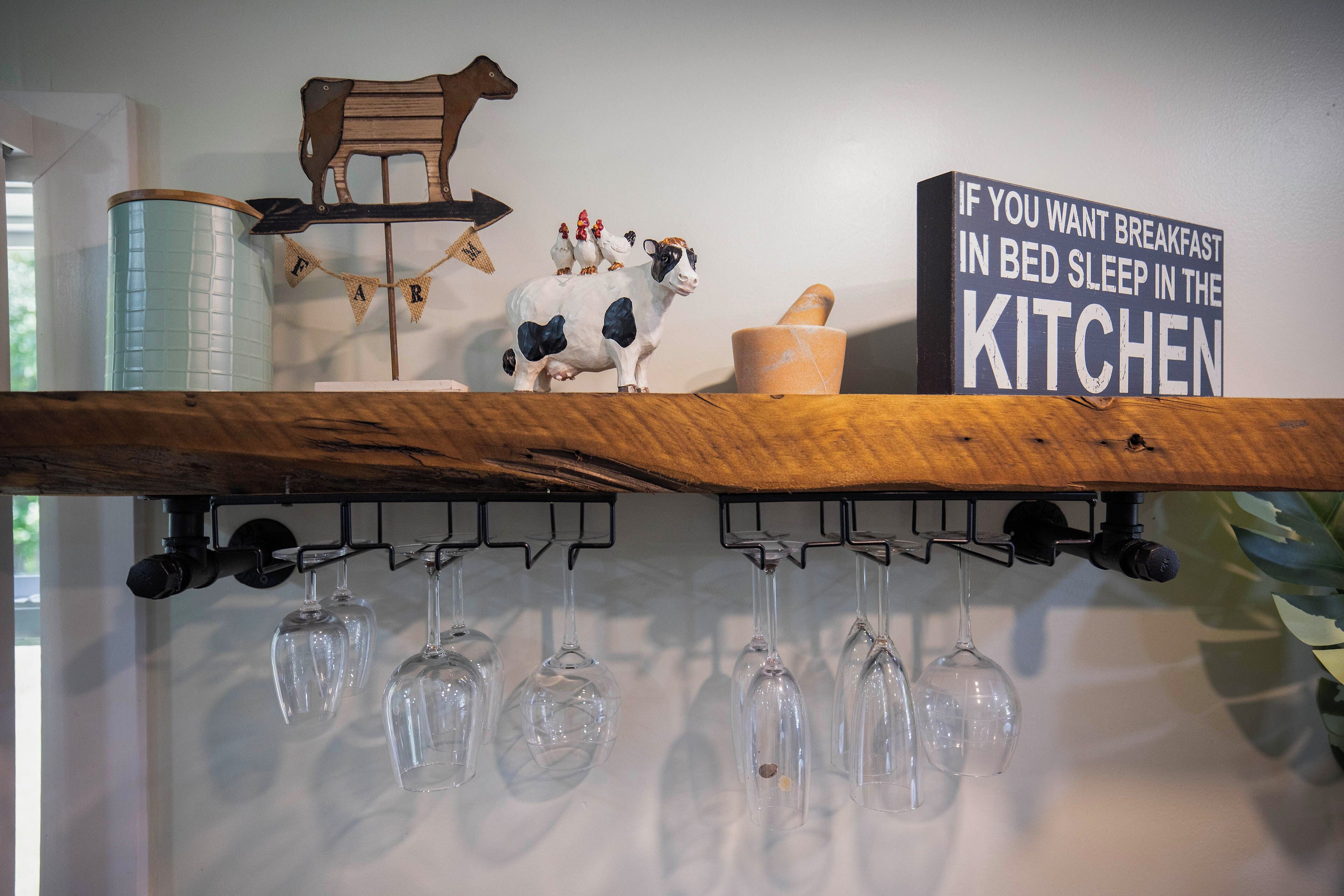 A kitchen shelf with a wooden cutting board, a sign, and a rooster figurine.