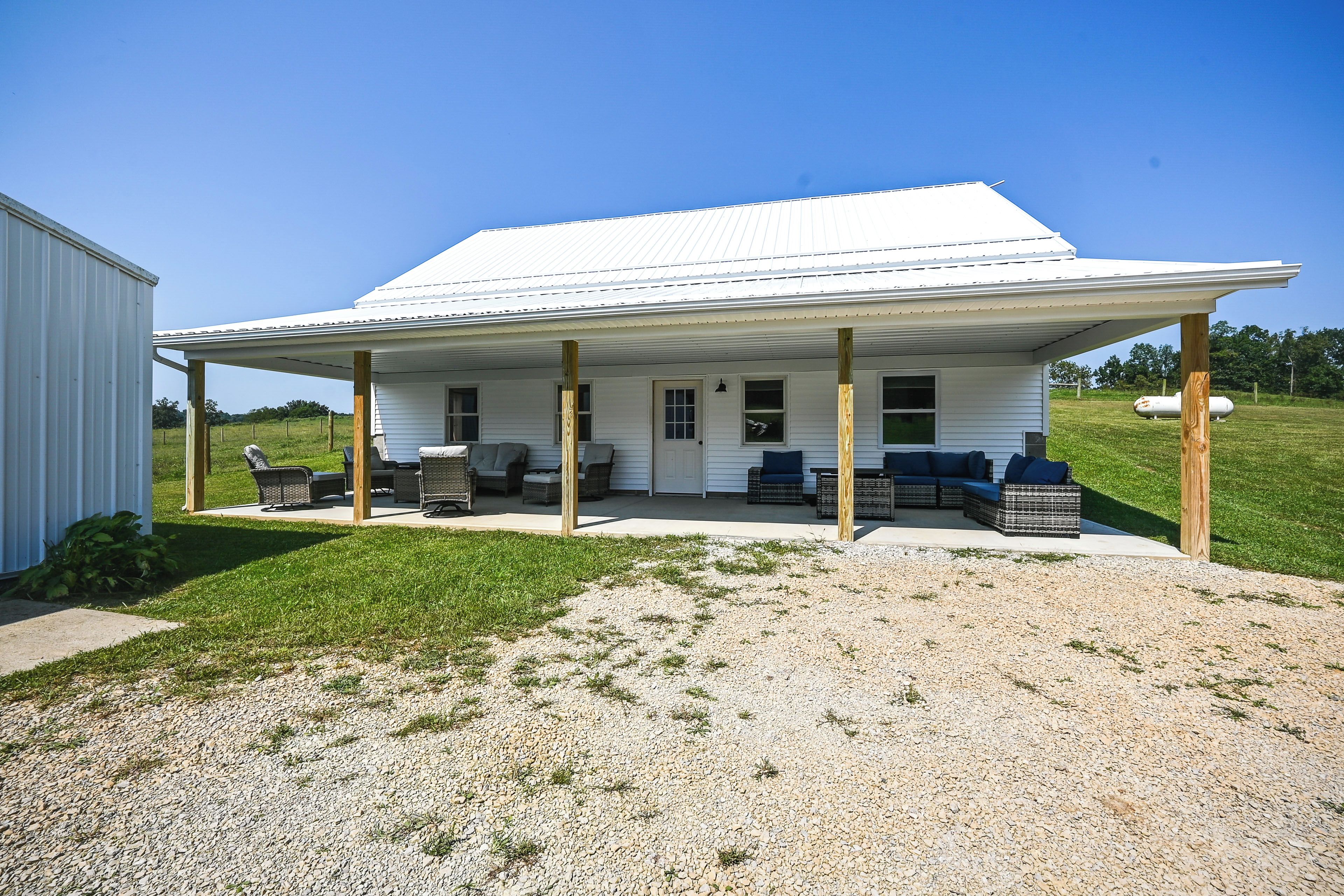 A single-story house with a covered porch and outdoor seating area.