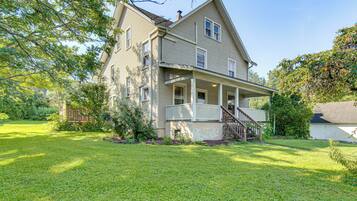 A two-story house with a front porch and a small staircase leading to the entrance.