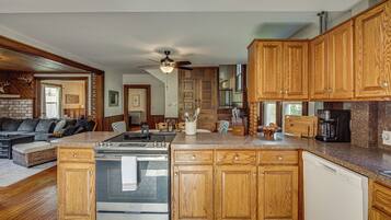 A modern kitchen with wooden cabinets, a stainless steel stove, and a granite countertop.